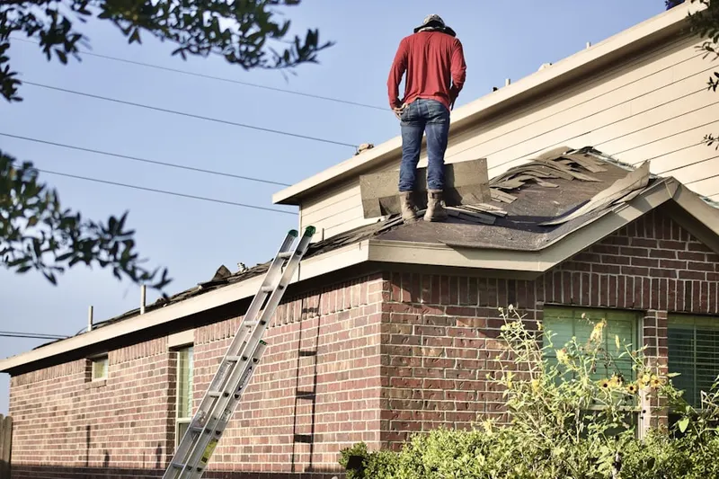 Professional roofer working on a residential roof in Dias